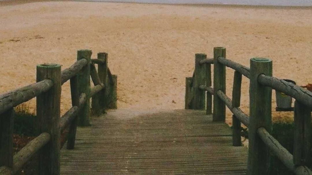 Wooden steps leading down onto an empty beach