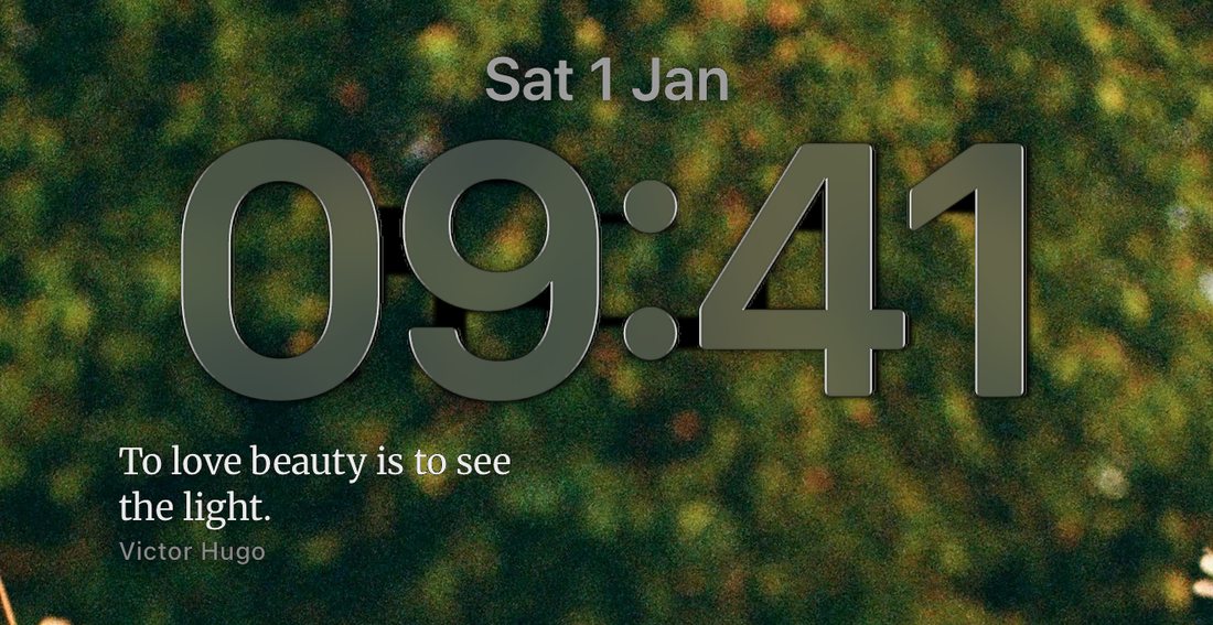 An iPhone Lock Screen with the line To love beauty is to see the light, Victor Hugo, under the clock