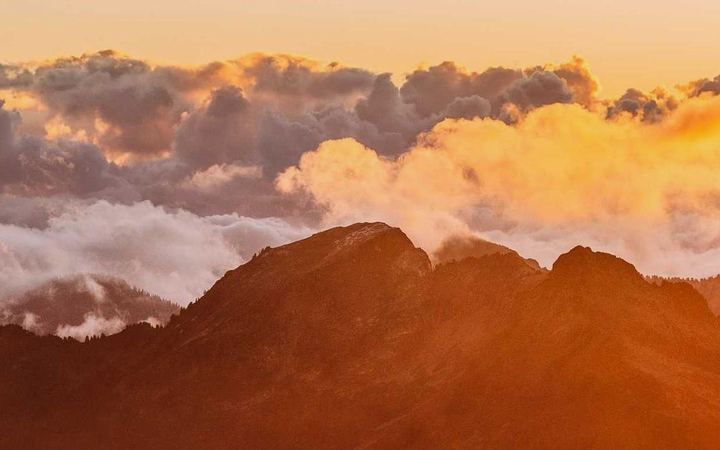 Sunrise over mountains above the clouds